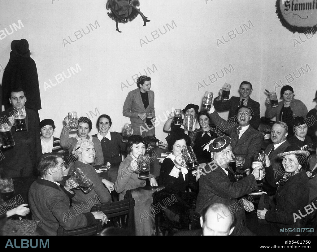 German men and women raising beer glasses Octoberfest 1936.