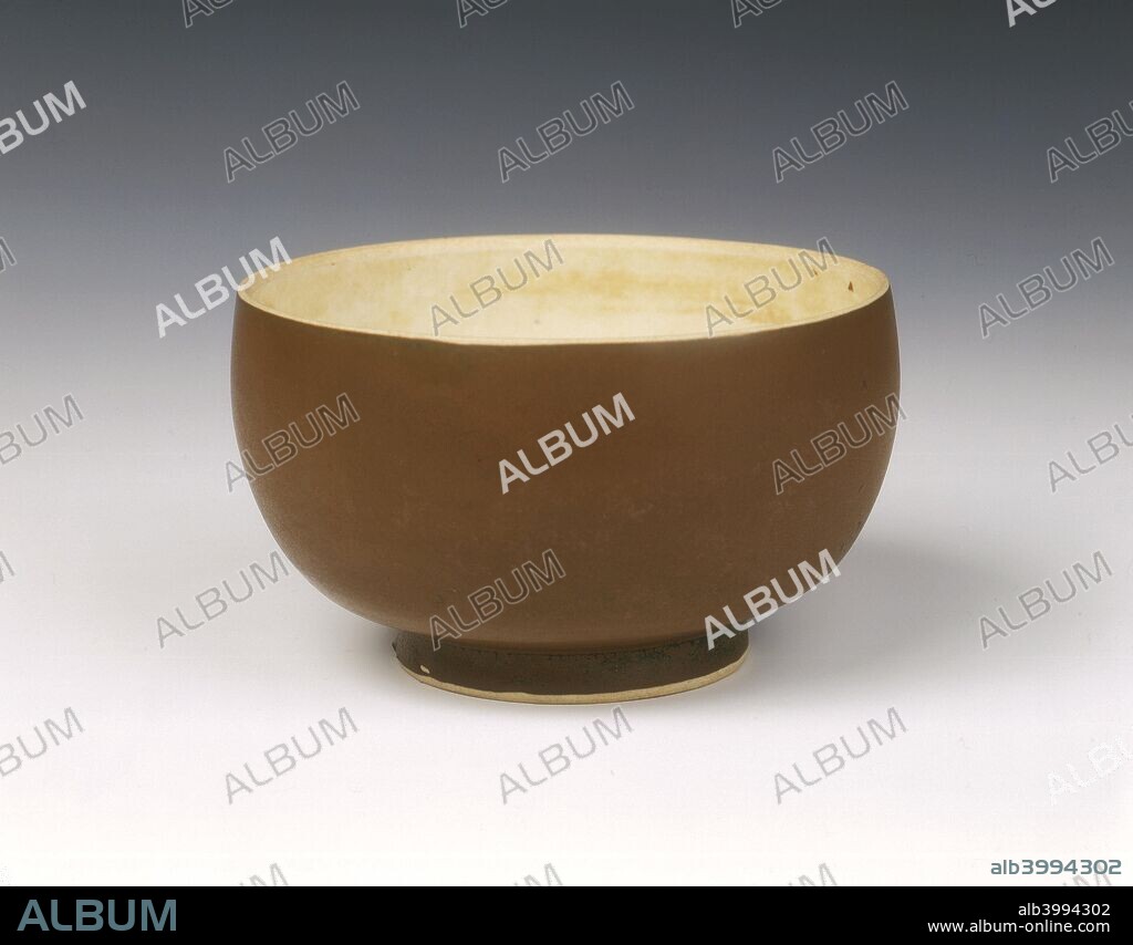 Persimmon red glazed Ding bowl with white glazed interior, Song dynasty, China, 12th century. A very rare red Dingyao bowl of deep rounded shape. The inside has a yellowish white glaze of Ding colour, the outside and the base are covered with a reddish brown rust glaze (called by the Japanese 'persimmon') with slight black suffusions on the base and over the foot. The foot rim and lip are unglazed to reveal the closely grained white typical Ding body.