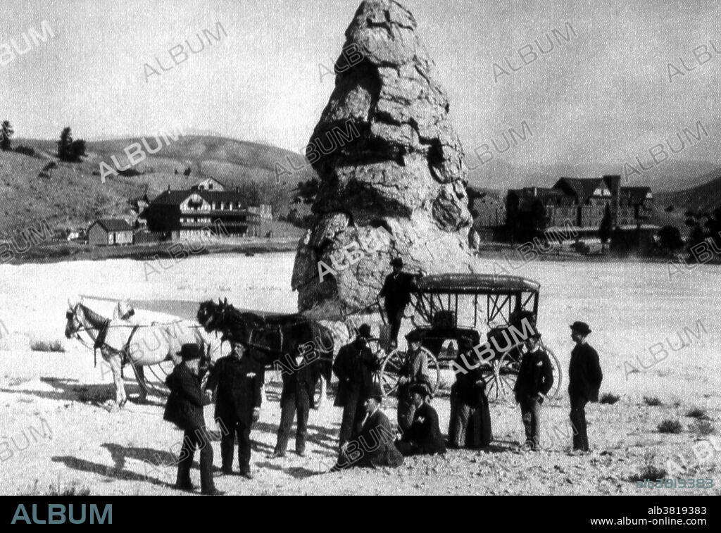 Tourist group at Liberty Cap. Photographer unknown, 1888. This 37 foot hot spring cone marks the northern portion of Mammoth Hot Springs. Liberty Cap was named in 1871 by the Hayden Survey party because of its marked resemblance to the peaked caps worn during the French Revolution. Its unusual formation was created by a hot spring whose plumbing remained open and in one location for a long time. Its internal pressure was sufficient to raise the water to a great height, allowing mineral deposits to build continuously for perhaps hundreds of years. Yellowstone National Park is a national park located primarily in the state of Wyoming, although it also extends into Montana and Idaho. It was established by the U.S. Congress and signed into law by President Ulysses S. Grant on March 1, 1872.