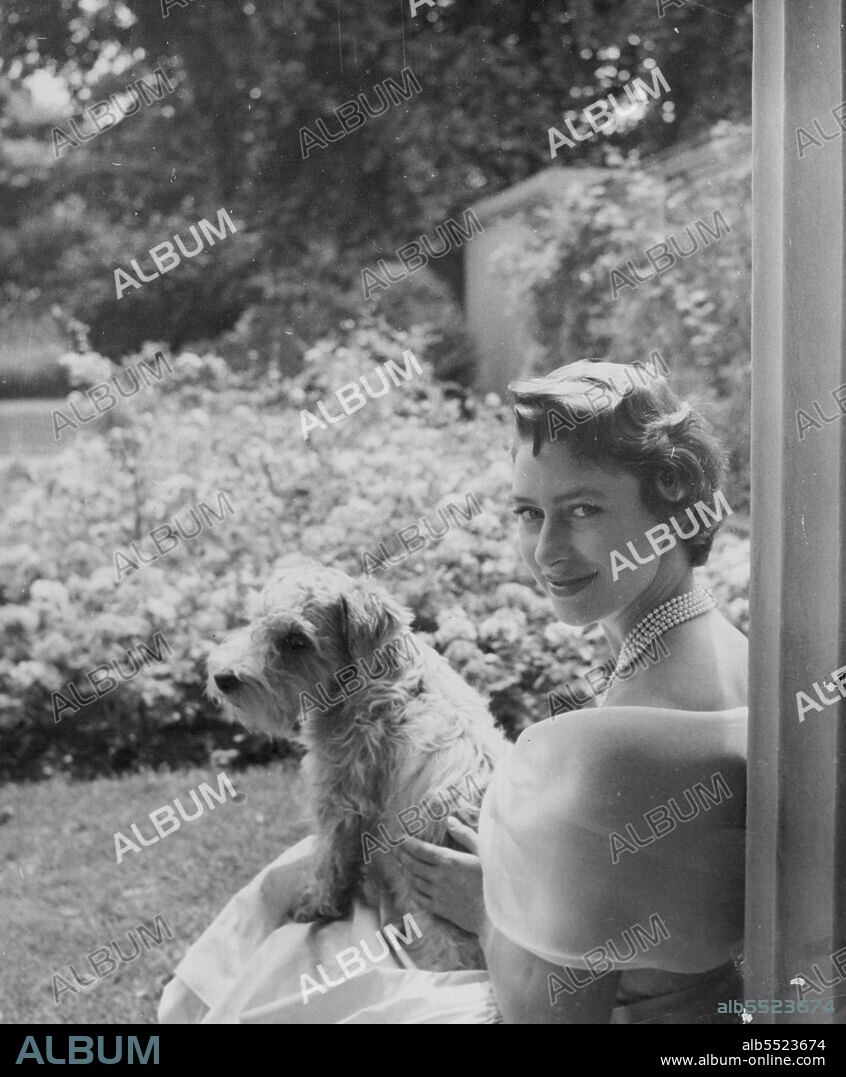 Princess Margaret - A new picture of Princess Margaret who is 25 on August 21. It was taken July 19 by Cecil Beaton in the garden of Clarence house. The Princess, who is with her Sealyham Pippin, wears a pale yellow dress of paper Shantung Taffeta with a collar of white organza, a five-string pearl necklace and a rose diamond brooch. August 21, 1955. (Photo by Cecil Beaton, The Associated Press Ltd.).