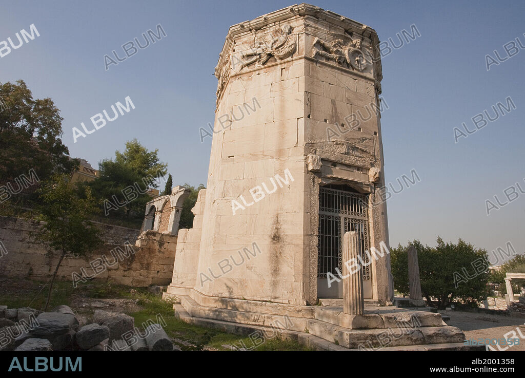 The Tower of the Winds (Aerides) or the Horologion of Kyrrhestos was built by the astronomer Andronikos from Kyrrhos in Macedonia. It is an octagonal tower of pentelic marble standing on a base with three steps. It has a conical roof, a cylindrical annex at the south side and two propyla at the NE and NW sides. A bronze weather-vane, with the figure of a Triton, indicated the direction of the winds, personifications of which are carved in relief at the top of each of the sides. Beneath each wind, curved rays in various forms consisted a sundial. During cloudy days and nights a water clock installations was used instead, in the building, for time calculations (mid 1st century BC).