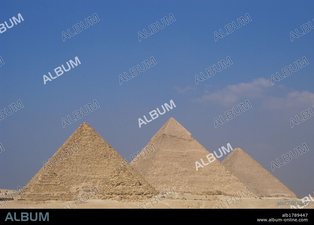 ARTE EGIPCIO. Vista desde el mirador de las tres pirámides. De izquierda a derecha: PIRAMIDE DE MENKAURA (MICERINOS), con sus tres pequeñas pirámides satélites. La PIRAMIDE DE JAFRA (KEFREN), que conserva intacta la capa de piedra caliza que recubre la cúspide. La Gran PIRAMIDE DE JAFU (KEOPS). IMPERIO ANTIGUO. IV DINASTIA. Siglo XXVI a. C. Meseta de EL GIZA. Egipto.