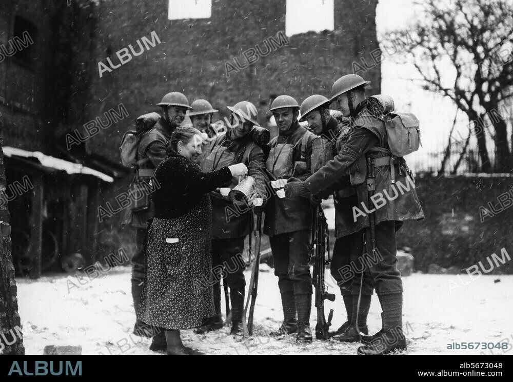 2. Weltkrieg / Frankreich:. Befreiung ("Liberation") nach der alliierten Invasion in der Normandie. (6.6.1944). Französin schenkt Tee an Soldaten des 1. Walisischen Garderegiments der britischen Armee aus (St. Nicholas, Arras). Foto, undat. (Winter 1944/45?).