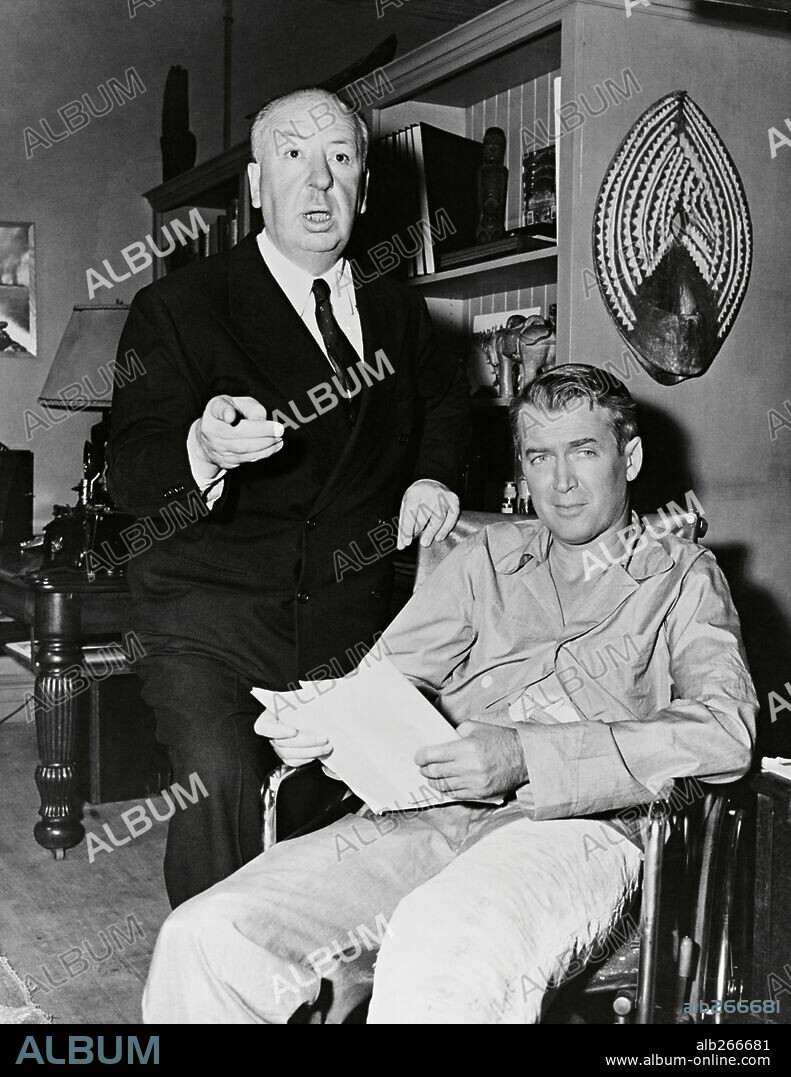 ALFRED HITCHCOCK and JAMES STEWART in REAR WINDOW, 1954, directed by ALFRED HITCHCOCK. Copyright PARAMOUNT PICTURES.