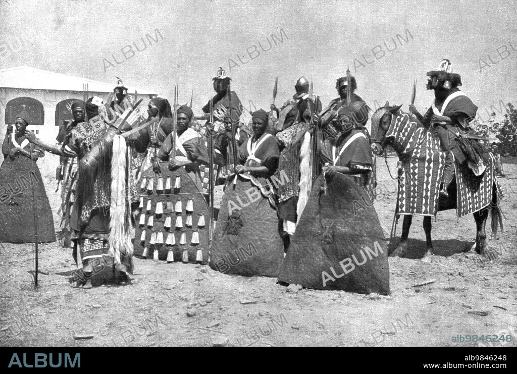 'Distant Fronts, In Cameroon; Escort of the lamido of Rey Bouba, the greatest black king of Cameroon, who came to greet Colonel Brisset; shield bearers and men-at-arms wearing authentic traditional dresss', 1917. From "L'Album de la Guerre 1914-1919, Volume 2" [L'Illustration, Paris, 1924].