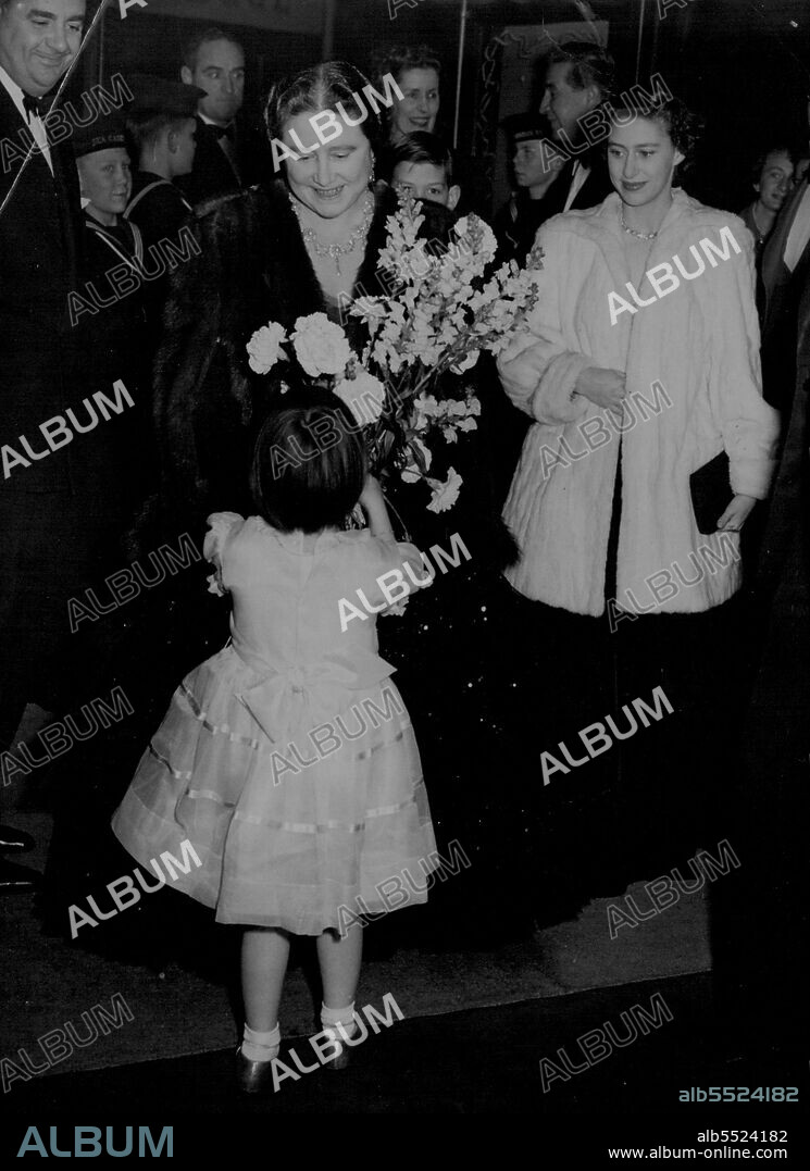 Smile for a 'Flower Girl' -- Queen Elizabeth, the Queen Mother gives a charming smile of acceptance as she receives a bouquet from Primrose Pearl Lawson-Jonston on arrival for the 'Jack and Jill' Pantomime at the London Casino this evening (Wednesday).The Queen Mother is accompanied by Princess Margaret and Prince Michael of Kent (behind). At left is smile Littler. December 17, 1952. (Photo by Reuterphoto).