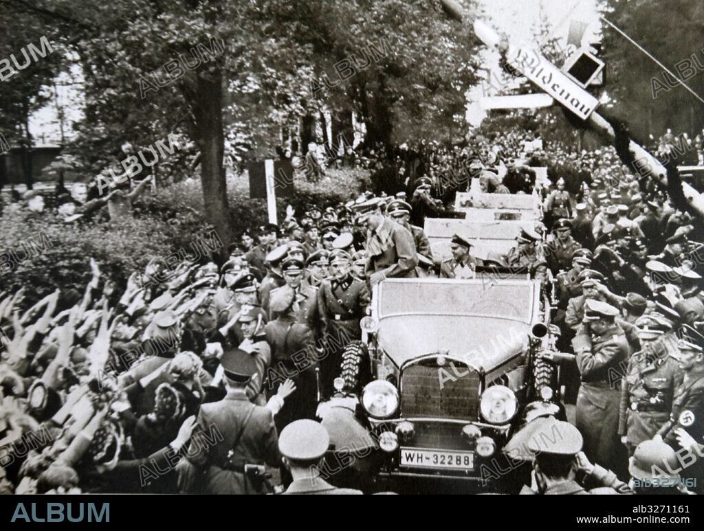 Photographic print of Adolf Hitler (1889-1945) a German politician, leader of the Nazi Party, Chancellor of Germany, and Fuhrer of Nazi Germany, driving through crowds in Luhe-Wildenau, Bavaria. Dated 20th Century.