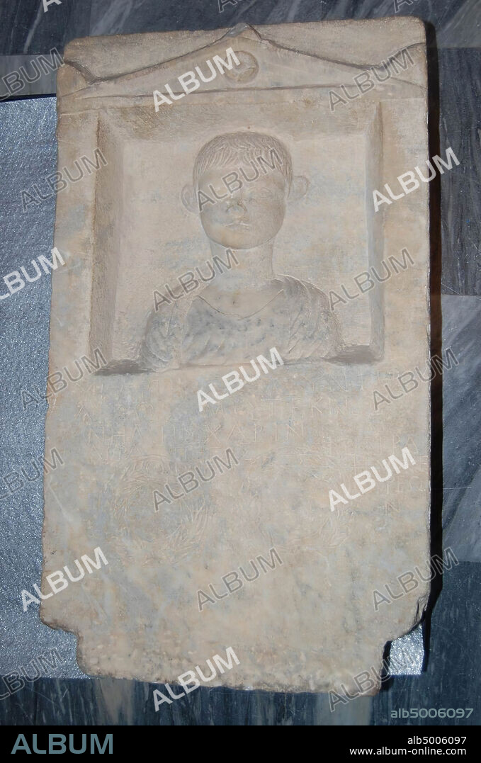 Rectangular grave relief with triangular pediment. Frontal a boy in chiton. Beneath the bust a three-line inscription and two burial wreaths with inscriptions. Name of deceased: Zosimos., Sculpture, grave relief, stone, marble, 83 cm, 142 kg, imperial time 0.
