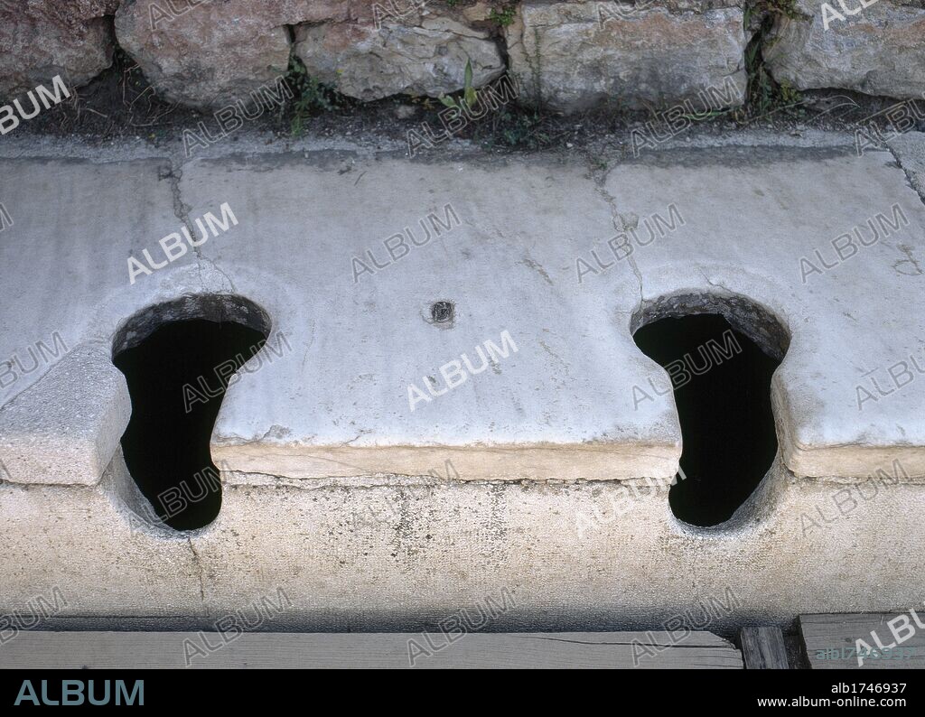 ARTE ROMANO. TURQUIA. LETRINAS PUBLICAS de la ciudad de EFESO. Fechadas en el siglo I d. C. Detalle de los RETRETES alineados en fila, sin ningún separador entre ellos. EFESO. Península Anatólica.