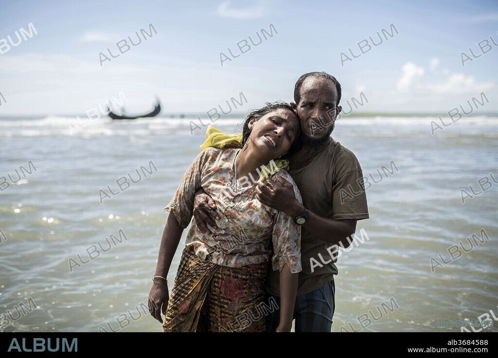 October 1, 2017 - Shah Porir Dwip, Coxs Bazar, Bangladesh - A man hugs his wife moments after getting off the boat and crossing the Naf River, escaping from the persecution of his people in Myanmar. (Credit Image: © Olmo Calvo/zReportage.com via ZUMA Wire). 01/10/2017