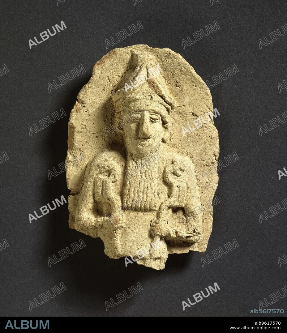 Votive plaque fragment, Old Babylonian, 1800-1600BC. Buff ware, bearded and horned crowned god holding animal-headed (lion?) staff in each hand, plaque broken off below waist. Dimensions: width: 7 cmheight: 10 cm.