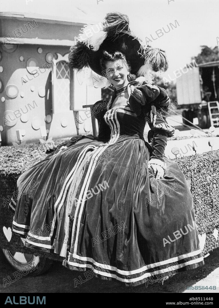 Orig. bildtext... BIG TOP LADY. CHICAGO, ILL. - FOLLOWING IN THE SAWDUST FOOTPRINTS OF HER BIG TOP FOREBEARS, MABEL RINGLING, OF THE FAMOUS CIRCUS FAMILY IS ONE OF THE TROUPE NOW APPEARING WITH THE RINGLING BROS. AND BARNUM AND BAILEY CIRCUS. SHE IS ONE OF MANY THE LINE TO BE INEVITABLY LINKED WITH THE THREE RINGS SINCE THE FIVE RINGLING BROTHERS TOOK TO THE ROAD WITH A WAGON SHOW IN 1884. Anm. Scenkläder Plymer Leenden Cirkusartister Klänningar Sammetsklänningar Cirkusprinsessor CD405 persons: MABEL RINGLING sites: USA.
