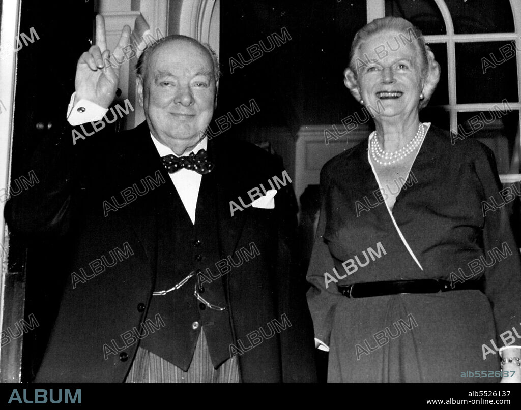Sir Winston Churchill, celebrating his 81st birthday Anniversary today November 30, makes the "V" sign as he poses with his life at the door of their London residence at Hyde Park Gate. November 30, 1955. (Photo by Associated Press Photo).