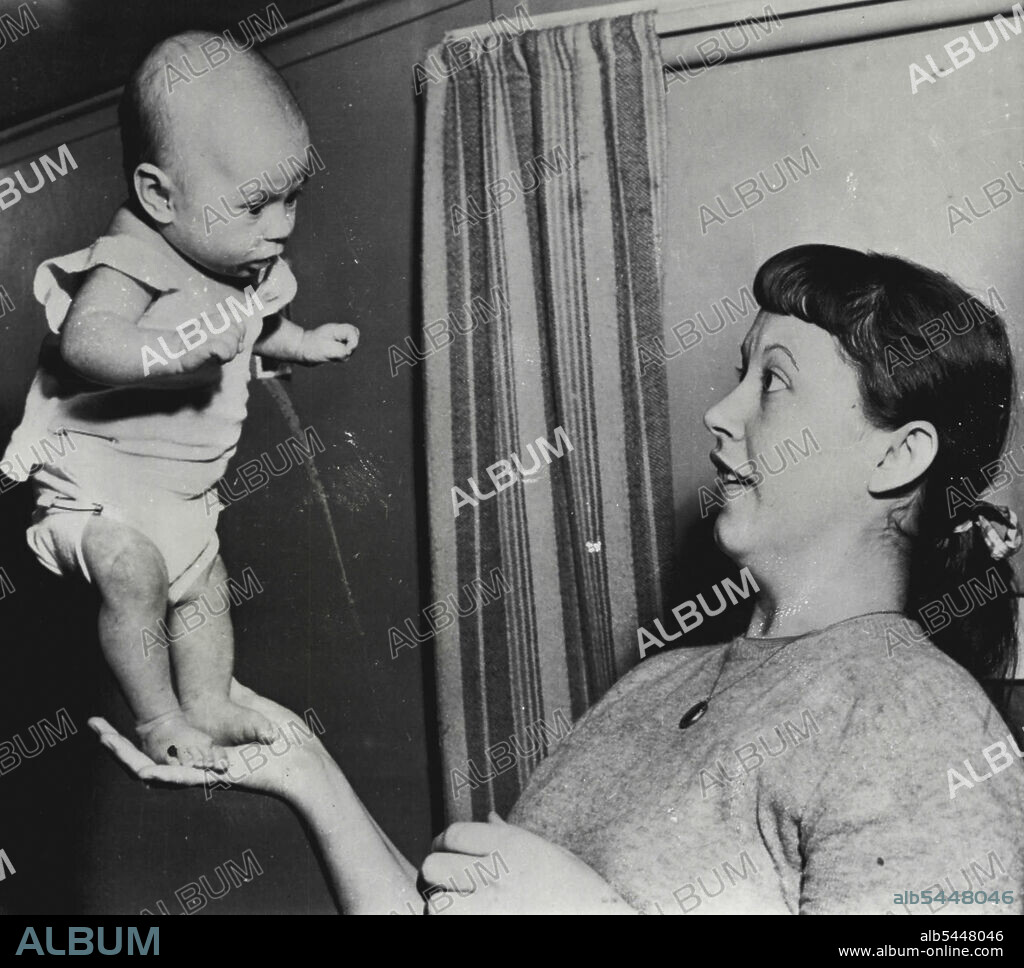 Super-Babe - Seven-Week-Old Susan Elaine Davey of Stockton Stands alone in the palm of the hand of her mother, Mrs. Edward Davey, 22, wife of a longshoreman and mother of three other children, the oldest eight years. Susan began standing alone a week ago and is attempting to walk. February 25, 1954. (Photo by AP Wirephoto).