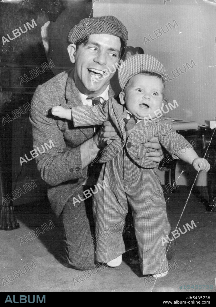 Christmas - I'm Ready For It - Bubbling over with Christmas fun and ready to throw him self about like father is Nicholas, his months-old son of comedian Norman Wisdom, who's restraining his effervescent youngster at the Empress Hall, London. Nicholas, about to celebrate his first Christmas, wears one of his presents - a suit just like dad's made for him by members of the 'Sinbad the Sailor on Ice' Show, in which Norman stars at the Empress Hall. December 23, 1953. (Photo by Reuterphoto).