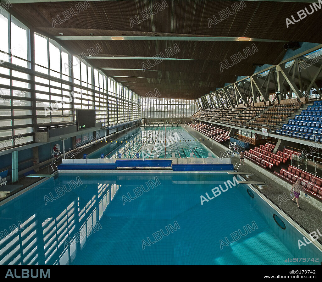 SIMON INGLIS. Crystal Palace National Sports Centre, Crystal Palace Park, Bromley, Greater London Authority, 2013. The swimming pool in the Crystal Palace National Sports Centre, seen from the diving platform at the north end. The National Recreation Centre was opened in 1964. It was built on the site of an exhibitions centre of the Crystal Palace Trust. When the designs were drawn up in 1953-1954, it was the first indoor multi-functional hall in Britain, incorporating both wet and dry sports in one building. The swimming pool side of the building houses a 50m pool, diving pool and learner pool. The building is Grade II* Listed.