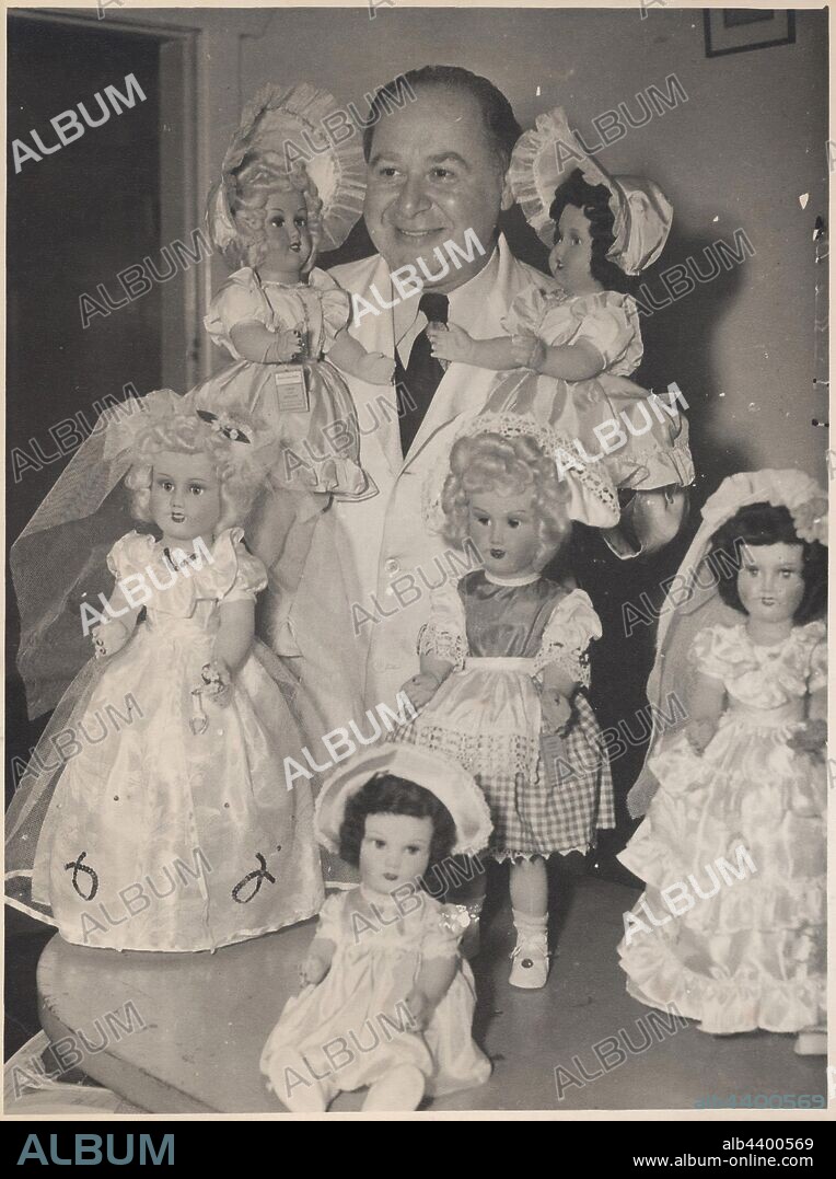 Photograph - L. J. Sterne Doll Co., Leo Sterne with Six Dolls in Dresses, Melbourne, Oct 1953, Black and white photograph of Leo Sterne posing with six dolls manufactured by the L. J. Sterne Doll Company. This photograph relates to products and promotions of the L.J. Sterne Doll Company (1939-1971), a Melbourne doll and toy manufacturer founded by Austrian migrants Leo and Hilda Sterne.