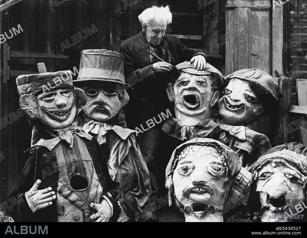 81-Year-old Barnum And Bailey Clown Still Makes Them Laugh -- 81-year-old Harry Russell photographed at work among some of his grotesque giant heads which he makes. In a white-washed shed in Norwood High Street, West Norwood, a youthful old man with a bushy mop of white hair continues a long life of making people laugh. 81-year-old Mr. Harry Russell was once a famous clown with Barnum and Bailey's circus, an claims to be its oldest survivor. He now spends his days making the giant papier mache.