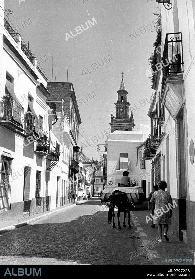 9 agosto 1974. Vista de una de las Calles del pueblo de Carmona (Sevilla), al fondo se Aprecia la torre de la iglesia.