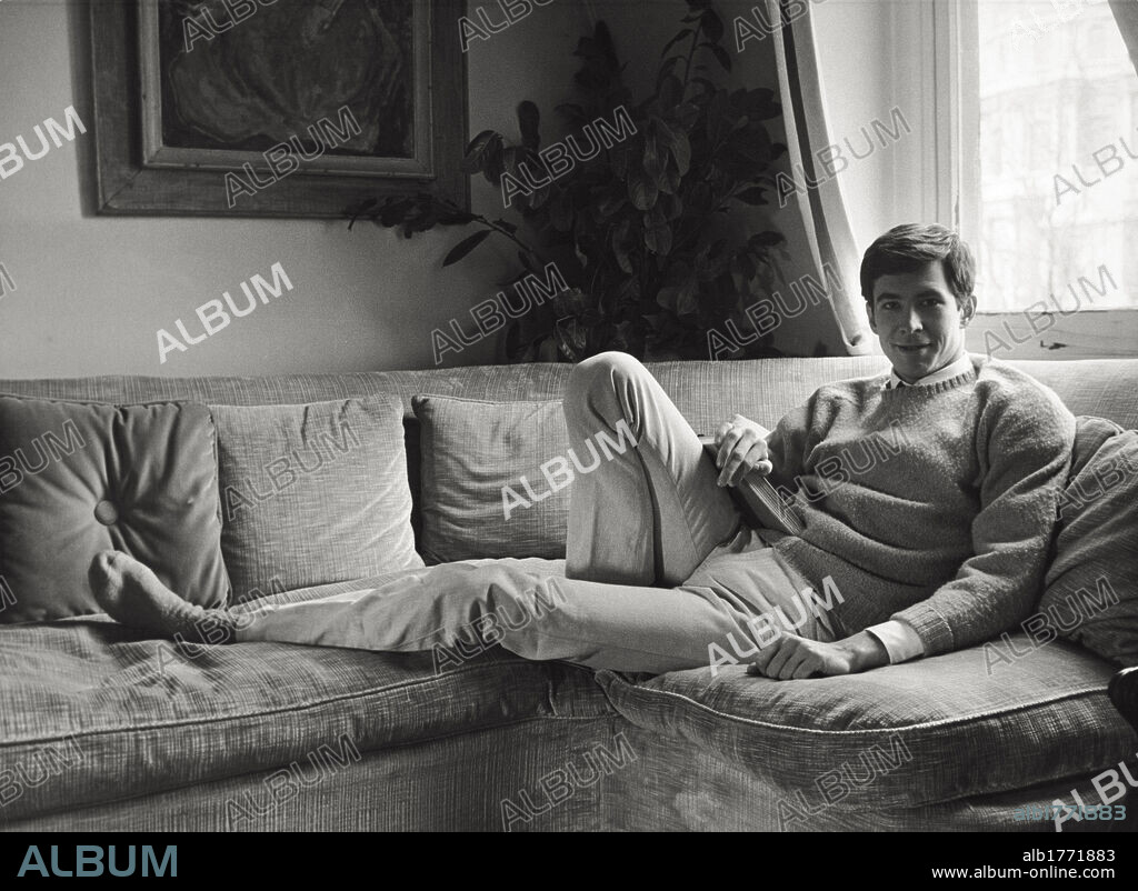 Anthony Perkins lying down. The American actor Anthony Perkins smiling lying down on a couch. 1960s.