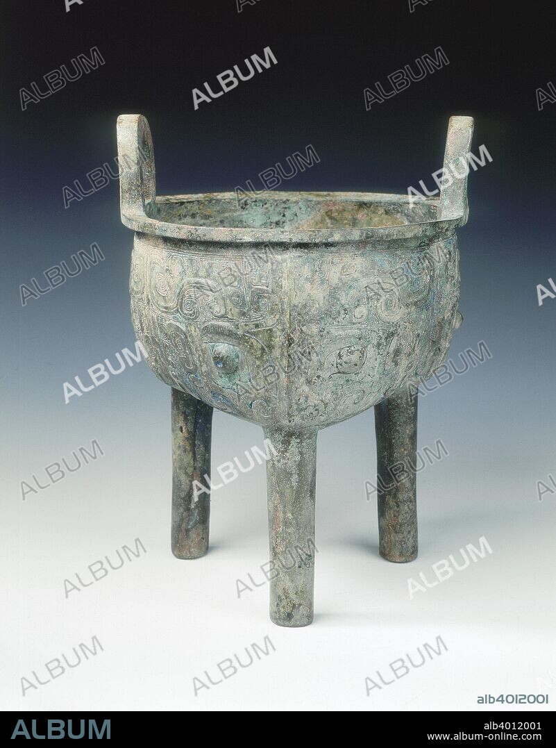 Bronze ding with taotie pattern, early Western Zhou dynasty, c1050 BC. A ritual bronze cauldron (ding) with upright loop handles supported on three plain cylindrical legs. The three lobes are each cast with a large and elaborate taotie mask, whose two large hooked horns flank a crest rising from its ridged nose, the jaws have tight hooks, the eyebrows are hatched and the eyes are in higher relief. A ding is a ritual vessel for cooked food with a round body and three legs.  The shape was made and used throughout Shang-Han dynasties.  Ritual vessls were used to offer food to ancestors.