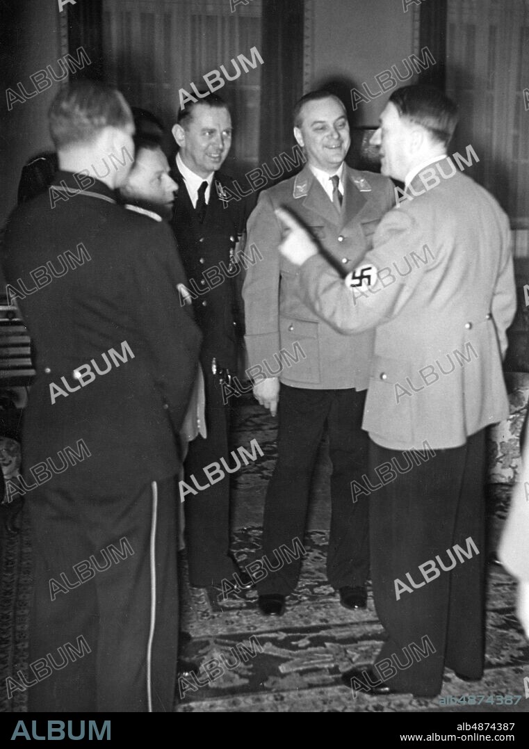 GERMANY 1938-01-12. Orig. caption ... ALFRED ROSENBERG 45 YEARS OLD. Adolf Hitler does not take it upon himself to convey his congratulations to his old rival Reichsleider Alfred Rosenberg, the author of "Mythos" and the first recipient of the German National Prize for Art and Science, personally on his birthday. - U.B.z .: The leader tells (from left) Reichsleiter Amann, Brigadier General Schaub and Alfred Rosenberg a funny story. Photo: Scherl Bilderdienst / AB Text & Bilder / SVT / Code: 5600 Folder: Rosenberg, Alfred A Rosenberg, 1893-1946, German Nazi ideologue and politician. Swastika Point Birthdays persons: ALFRED ROSENBERG; ADOLF HITLER; MAX AMANN; JULIUS SCHAUB sites: GERMANY.