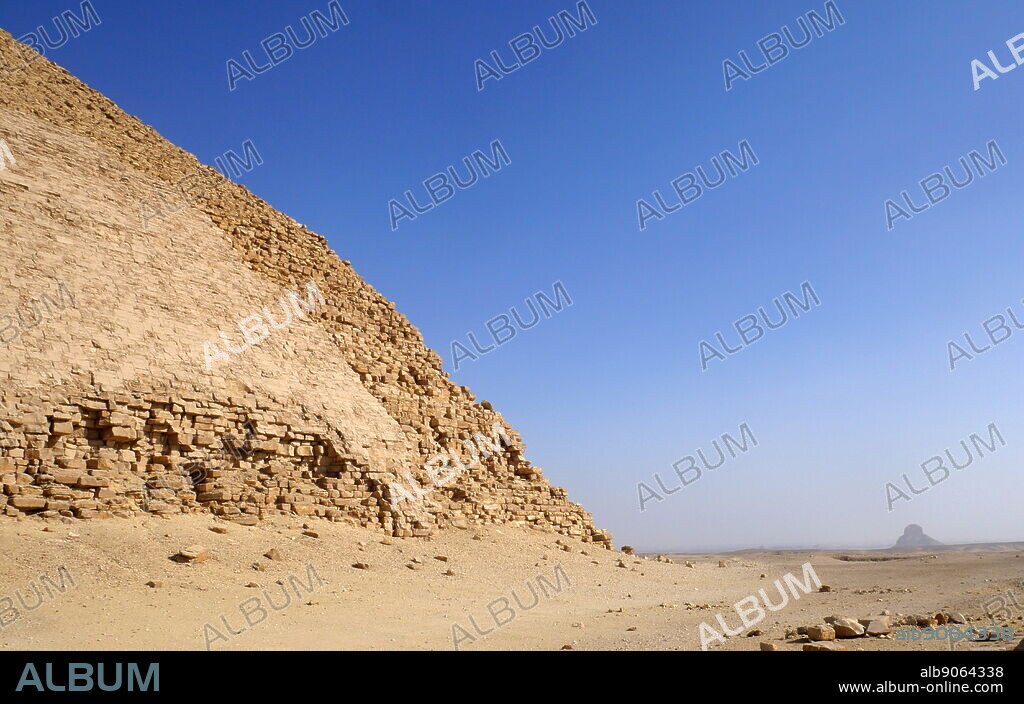 The Bent Pyramid is an ancient Egyptian pyramid located at the royal necropolis of Dahshur, approximately 40 kilometres south of Cairo, built under the Old Kingdom Pharaoh Sneferu (c. 2600 BC). A unique example of early pyramid development in Egypt, this was the second pyramid built by Sneferu. The Bent Pyramid rises from the desert at a 54-degree inclination, but the top section (above 47 meters) is built at the shallower angle of 43 degrees, lending the pyramid its very obvious 'bent' appearance.