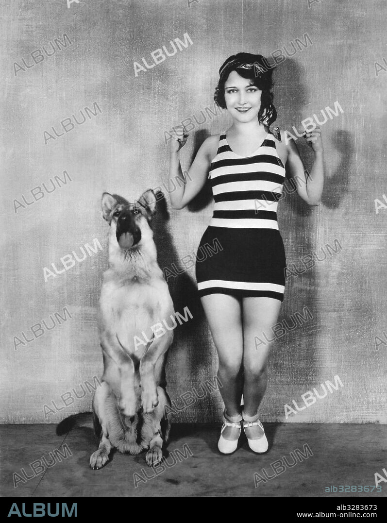 Hollywood, California:  c. 1927 Movie stars Dorothy Sebastian and Flash the Wonder Dog  do their set up exercises together.