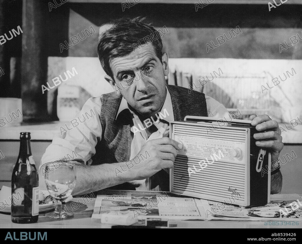 1960-tal.. Orig. bildtext... TV-TEATERN GER MÅNDAGEN DEN 17 JANUARI KL 20.00 Arnold Weskers pjäs Hotet i regi av Johan Bergenstråhle. Handlingen tilldrar sig i ett hyreshus i London. Rut (Karin Kavli) har tre år kvar till pensionen, om hon inte blir blind innan dess. Max(Tor Isedal) drömmer om att vinna på tips. Daphne (Dagny Stenius) har en bror i fängelse som hom skriver till varje dag. Dessa tre spelar canasta tillsammans med Peter (Gösta Ekman) två gånger i veckan utan att någon för den skull kommer ur sin ensamhet. Övriga medverkande: Lena Granhagen, Sten Moberg, Peter Forssell och Philip Sinai. Anm. TV-pjäs sänd 1966-01-17 Transistorapparater Ölflaskor Blicken T. Isedal, tidigare Carlsson, 1924-1990, skådespelare. CD331 persons: TOR ISEDAL sites: SVERIGE.
