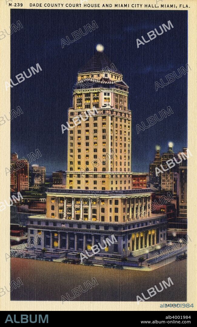 Miami-Dade County Courthouse, Miami, Florida, USA, 1933. Vintage linen postcard showing a night view of the Dade County Courthouse and Miami City Hall, a building built in the Classical Revival style. When completed in 1928 the courthouse was the tallest building in Florida. It was designed by A Ten Eyck Brown and August Geiger. The top nine floors of the building used to contain jail cells. Because of the height they were considered to offer the maximum security and to be escape proof, but over the time that prisoners were kept there 70 managed to escape.