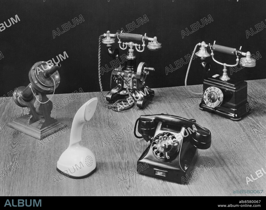 1959.. Orig. bildtext...Några L M Ericsson-telefoner av olika årgångar. I Bakgrunden t.v. en modell från 1879, tillverkad av Lars Magnus Ericsson, i mitten den världsbekanta telefonapparaten med handmikrofon, som introducerades 1892, t.h. 1923 års telefon med fingerskiva. I förgrunden t.h. den moderna apparaten i plast, introducerad 1931 och t.v. L M Ericssons senaste apparatskapelse Ericofon - allt i ett-telefonen - som introducerades 1956. Anm. Design Form Kobratelefon CD328 sites: SVERIGE.