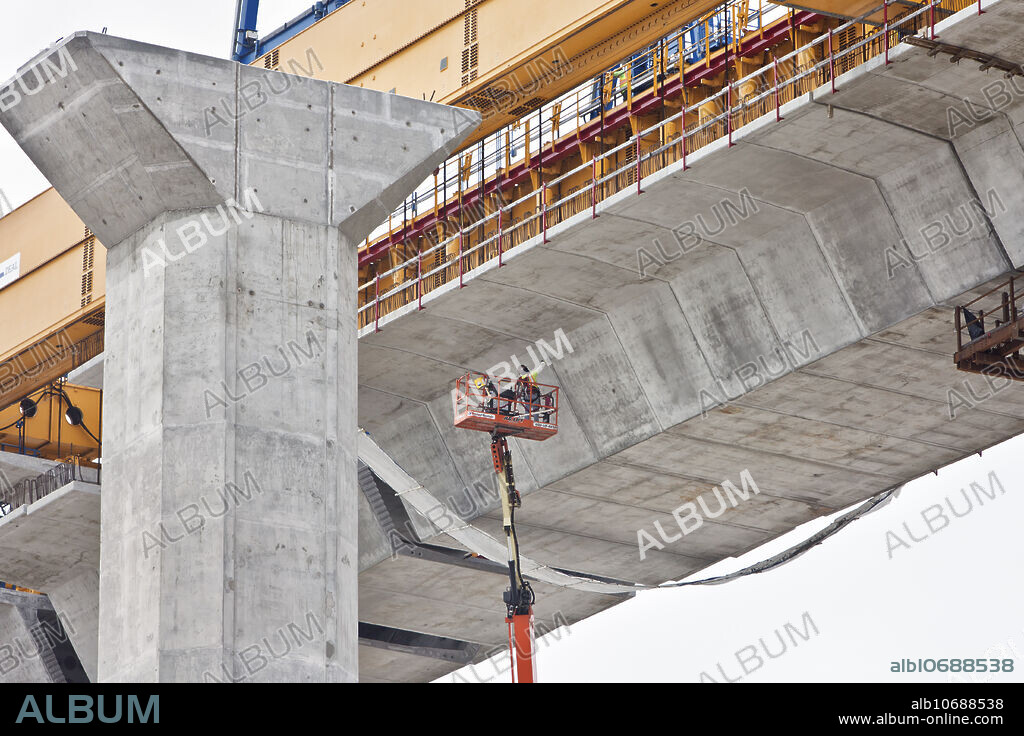 New Harbor Bridge construction, crosses the Corpus Christi Ship Channel which serves the port of Corpus Christi, Six-lane cable-stay, concrete-segmental bridge, Rising to a height of 163 metres at the peak, two box girders. Completion is estimate Spring 2022. Worker suspended with extended power lift, cleaning cement joints under the bridge, Corpus Christi, Texas, Nueces County, USA.