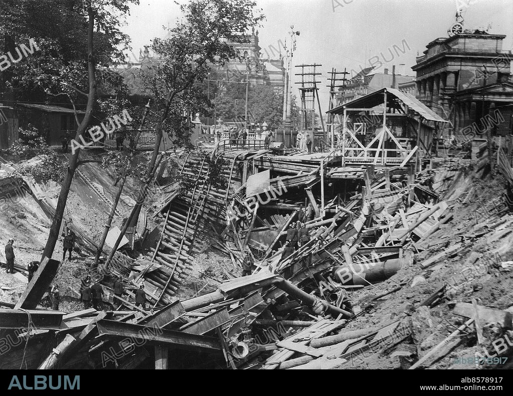 TYSKLAND BERLIN 1935-08. Orig. bildtext... S-BAHN TUNNEL AM BRANDENBURGER TOR EINGESTÜRZT. Beim Bau des Nord-Südbahn Tunnels, der den Stettiner mit dem Anhalter Bahnhof verbinden wird, ereignete sich am 20.8. mittags ein schweres Einsturzunglück, bei dem ein riesiger Kran und die benachbarten Strassenbahnschienen mit in die Tiefe gerissen wurden. Blick auf die Einsturzstelle in der Hermann Göring-Strasse. (Vom Reichspropaganda-Ministerium zur Veröffentlichung freigegeben!) Foto: Robert Sennecke / AB Text & Bilder / SVT / Kod: 5600 Mapp: Tunnelraset i Berlin augusti 1935 2530 E Ras vid tunnelbygge för pendeltåg (S-Bahn). Bildserier Fotoreportage Arbetsplatsolyckor Räddningsarbete sites: BERLIN;TYSKLAND PhotoDate:1935-08-??.