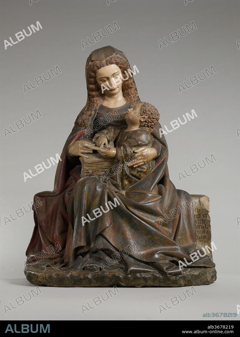 Virgin and Child. Artist: Attributed to Claus de Werve (Netherlandish, active in France, ca. 1380-1439, active Burgundy, 1396-ca. 1439). Culture: French. Dimensions: Overall: 53 3/8 x 41 1/8 x 27 in. (135.5 x 104.5 x 68.6 cm). Date: ca. 1415-17.
This monumental yet intimate image of the Virgin and Child was probably a gift of John the Fearless, Duke of Burgundy (d. 1419), or his wife, Margaret of Bavaria (d. 1424), to the convent they founded dedicated to the Franciscan order of Poor Clares at Poligny. As court sculptor to the Burgundian dukes in Dijon, the influential artist Claus de Werve, to whom this sculpture is attributed, created many works for his patrons, and this sculpture is one of his masterpieces. The curly-headed child Jesus looks up at his mother as she balances him and a large book on her lap. This tender moment between mother and son is, at the same time, a presentation of a sophisticated theological theme. The clue to understanding it is the Latin inscription on the bench. Taken from the Book of Ecclesiasticus, dedicated to and extolling wisdom, it reads, "From the beginning, and before the world, was I created" (24:14). Although by the thirteenth century the Church applied this text, which refers to Wisdom as a feminine entity, to discuss Mary, it was Christ as God incarnate who was seen as the personification of divine Wisdom on earth and Mary the vessel, or throne, that bore him.