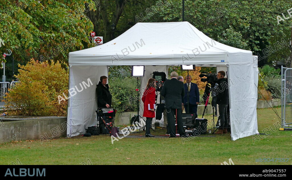 Tamara Cohen (red coat) a Sky News political correspondent prepares for interviews on College Green, Parliament, London. September 2019.