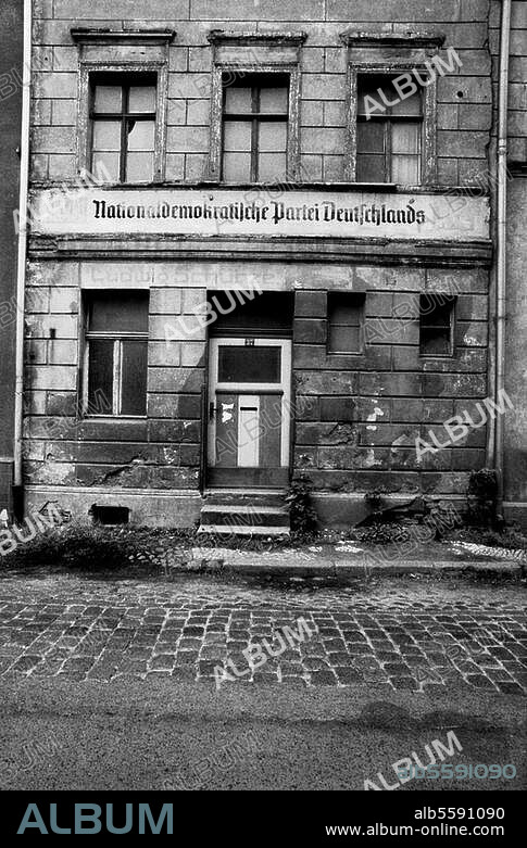 zu: Geschichte:. Deutschland / DDR. Vernachlässigung der Altbausubstanz in der DDR: Verwitterte Fassade eines Hauses in Wittenberg, Mittelstraße, mit dem Schriftzug "Nationaldemokratische Partei Deutschlands". Foto, 28.6.1990.