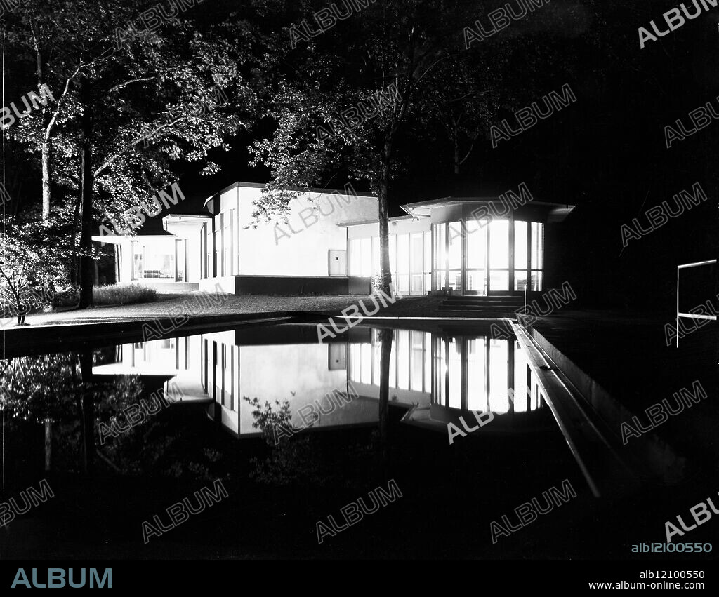 Exterior night time view of the B.J. Cahn residence with a reflection in the swimming pool, designed by architects Keck & Keck, located at 270 South Western Avenue, Lake Forest, Illinois, July 29, 1938. Photographed for Architectural Forum and Keck & Keck.