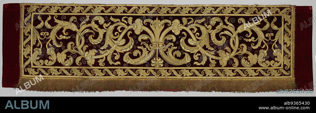 Lambrekine or strip of applique embroidery, Lambrekine or strip of applique embroidery on a wine red velvet fond. The pattern has symmetrical reclining S tendrils, tied together in the center with a lily and a rose. The richly branched tendril is set with leaf rosettes and ends in volutes of acanthus leaves and silver sutured tendrils. The strip is finished with gold passement and gold fringe along the bottom. The strip belongs to three strips., anonymous, Italy (possibly), c. 1500 - c. 1600, velvet (fabric weave), silk, embroidering, length 190.0 cm × width 60.0 cm.