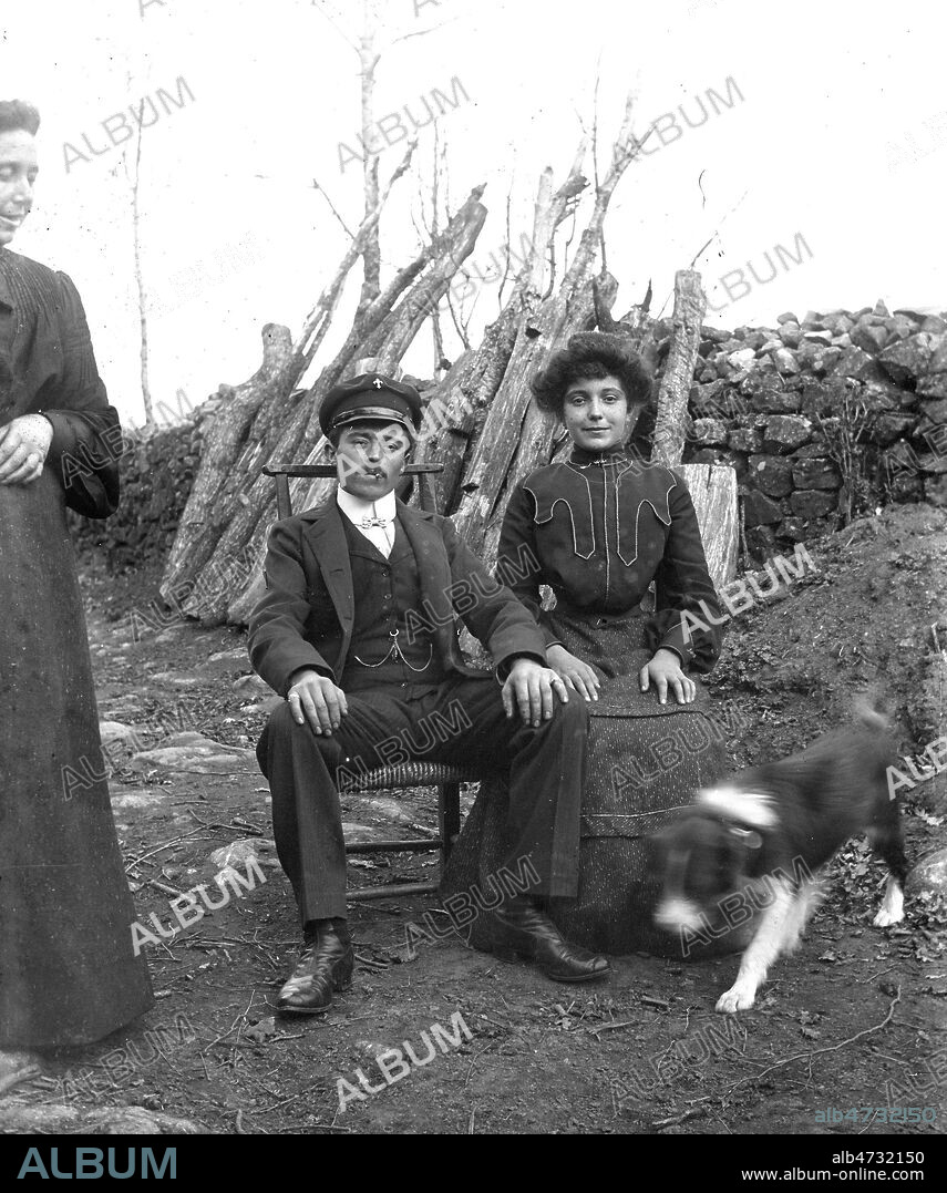 Jeune couple et belle-mere, Photo d'amateur, vers 1900. Le chien a bougé, et la belle-mère essaie de s'introduire dans l'image, a gauche. Les deux tourteraux ont leurs mains posees sagement sur leurs genoux. Credit JEAN VIGNE/KHARBINE TAPABOR.