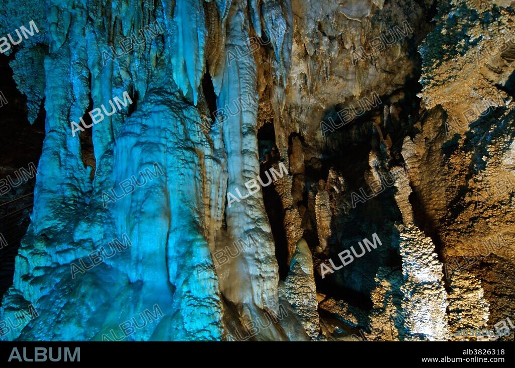 Tubular column, 4 meters tall, with blue lights on the tourist trail inside Antro del Corchia, the largest cave complex in Italy.