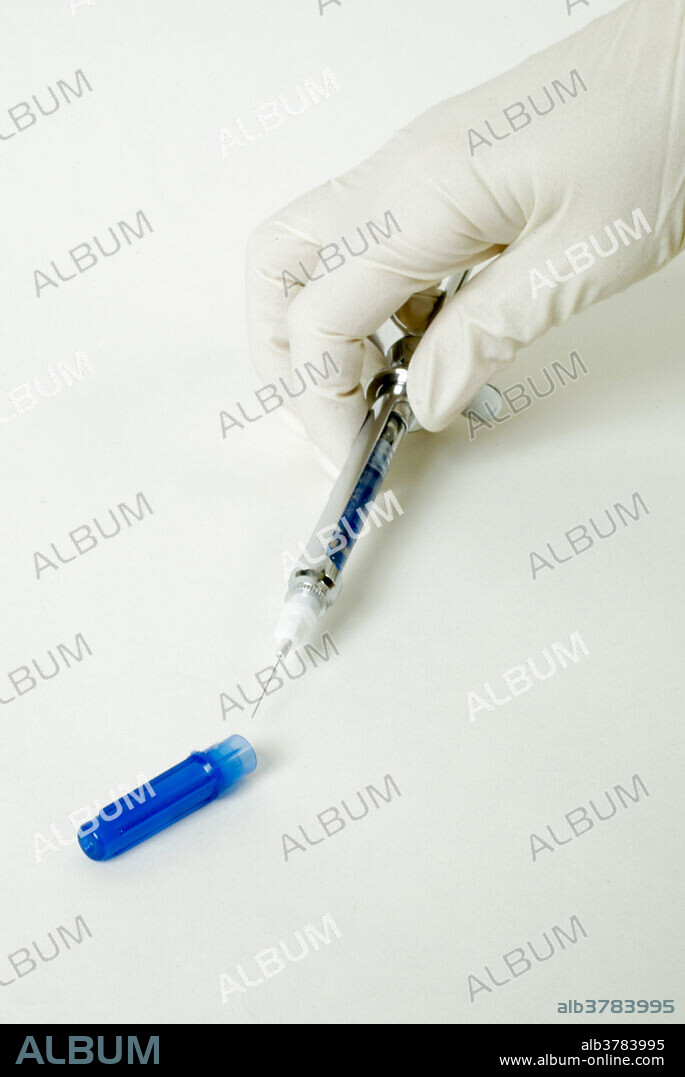 Correct capping procedure for a novocaine carpule in an anaesthetic syringe is demonstrated by a dentist. A carpule is a type of ampule or cartridge containing liquid medication.