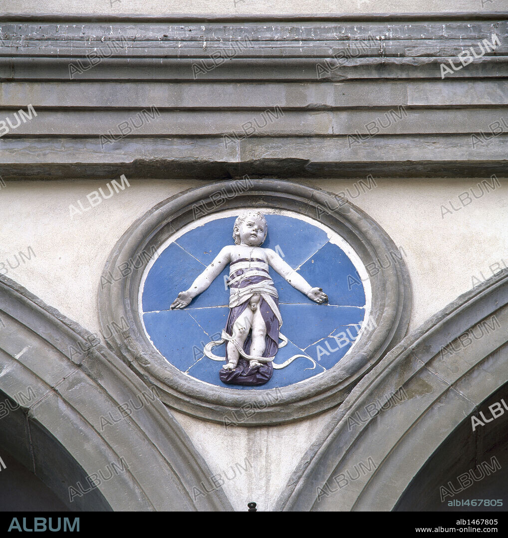 ARTE RENACIMIENTO-QUATTROCENTO. ITALIA. ROBBIA, Andrea della (Florencia,1435-Florencia, 1528). Escultor y ceramista italiano. Detalle de uno de los MEDALLONES con fondo azul y relieve de NIÑO EN PAÑALES, existente entre las arcadas exteriores del pórtico del HOSPITAL DE LOS INOCENTES (SPEDALE DEGLI INNOCENTI), construido por Brunelleschi (1421-1424). FLORENCIA.