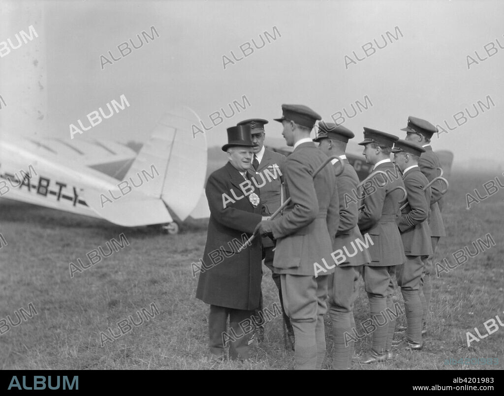 Visiting dignitary meeting airmen at Heston Aerodrome, Hounslow, London, c1933-c1935. The plane in the background is a Spartan Cruiser passenger aircraft operated by Spartan Air Lines Limited on the London-Cowes (Isle of Wight) route between 1933 and 1935. It crashed in the Channel in May 1935.