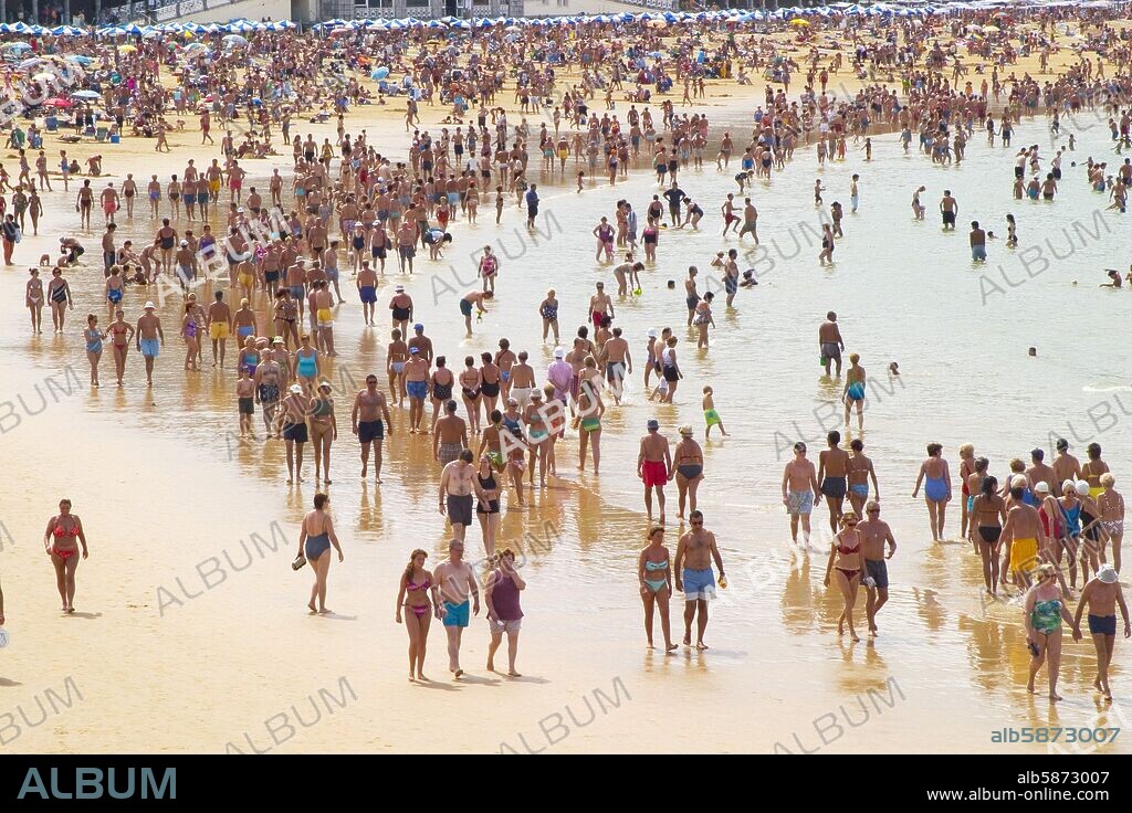Donostia / San Sebastian; playa de La Concha, gente paseando durante la bajamar.