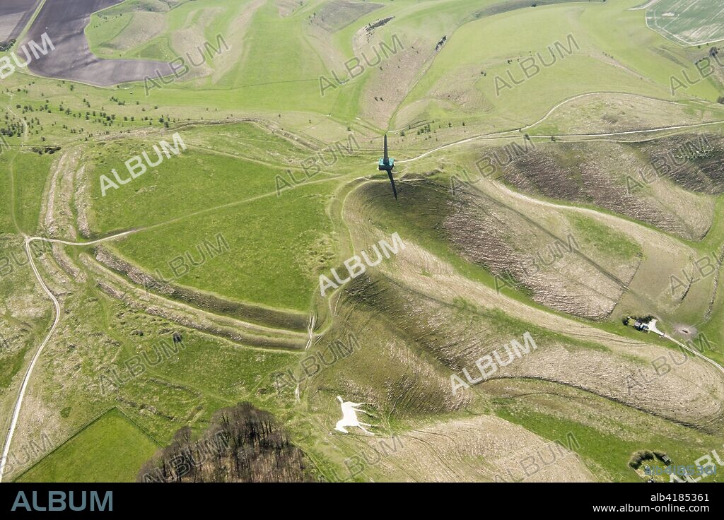 Cherhill Down, Wiltshire, 2018. Aerial view showing the Cherhill White Horse, Oldbury Castle bivallate Iron Age hillfort earthwork and the Lansdowne Monument. The monument is a 125 foot tall stone obelisk erected by the 3rd Marquis of Lansdowne in 1845 in honour of his ancestor Sir William Petty (1623-1687).
