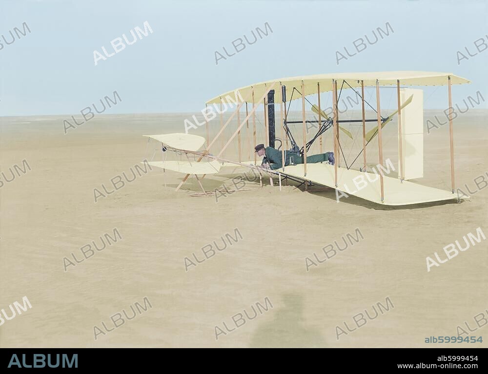 Wright, Wilbur; USamerikan. Flugpionier (Mitarbeiter seines Bruders Orville Wright); 1867-1912. /-Wilbur Wright in dem beschädigten Doppeldecker-Motorflugzeug nach dem gescheiterten Flugversuch am 14.12.1903 in Kitty Hawk, North Carolina, USA (erster gelungener Flugversuch am 17.Dezember 1903).-/Foto, 14.12.1903 (Orville Wright); digital koloriert.