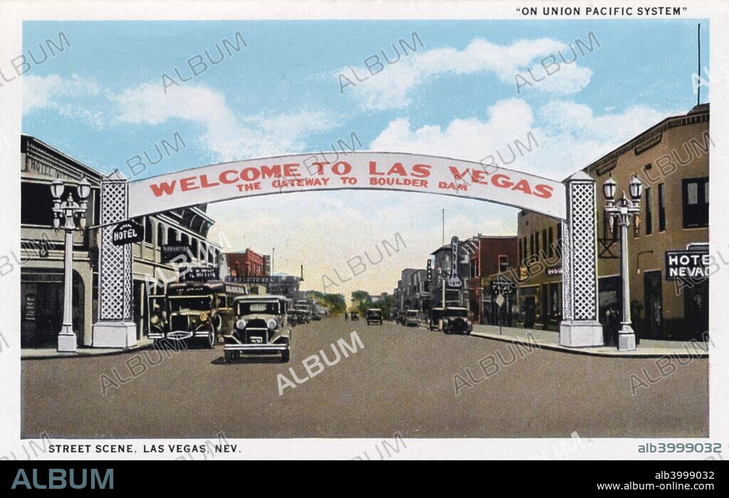 Welcome to Las Vegas sign, Las Vegas, Nevada, USA, 1930. The sign describes Las Vegas as The Gateway to Boulder Dam. Vintage postcard image showing the welcome sign spanning Fremont Street. The Hotel Nevada is in the foregroung.  Vintage automobiles travel the street and the fronts of other businesses are also visible.