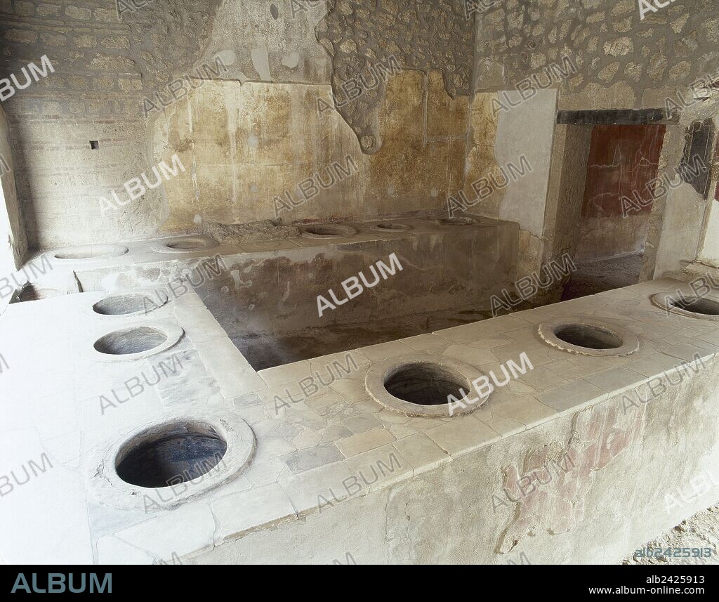 Italy. Pompeii. Ancient Roman city destroyed by the eruption of the Vesuvius in 79 AD. Bar  counter with holes where jars were set into them (dolia) for food or wine.  Campania.