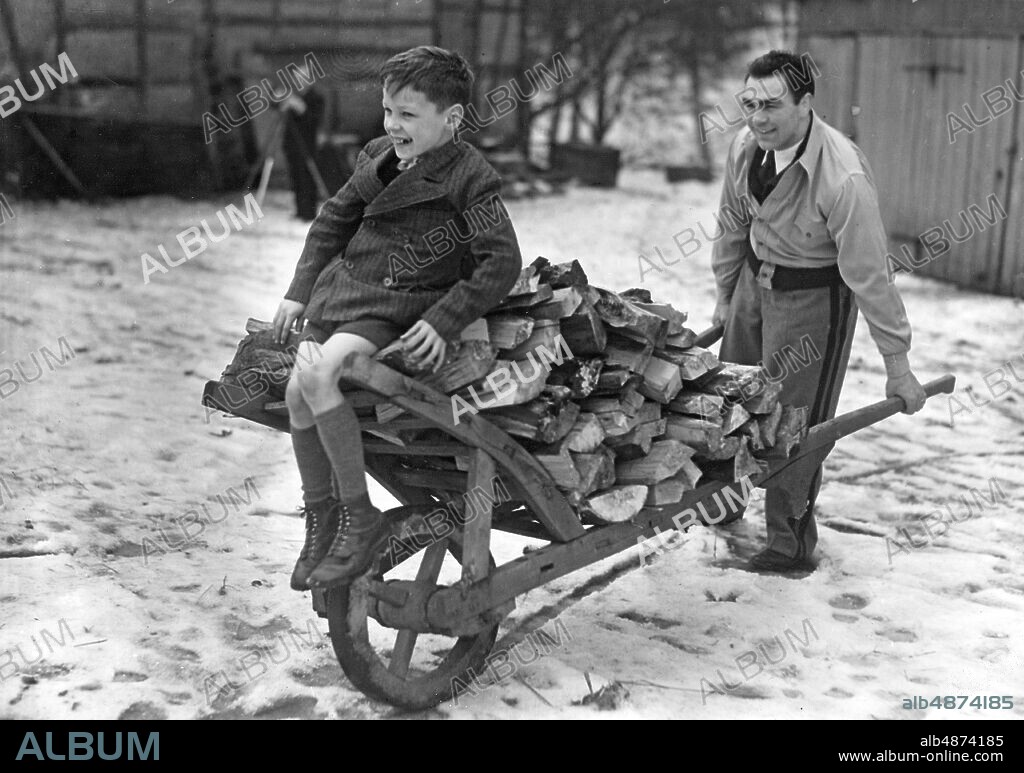 GERMANY HAMBURG 1938-01-08 Orig. caption ... MAX SCHMELING IN THE TRAINING CAMP Our image reporter visited the German master of all classes Max Schmeling in his training quarters in the Forrest House Friedrichsruh near Hamburg, where Schmeling on the weekend began the preparation for his fight against Ben Foord on January 30 in the Hanseatic Hall. U.B.z .: Already on Friday and Sunday afternoon, still during the establishment of the "camp", the light exercise training, running and chopping wood, set in. This neat image was created. On Sunday afternoon, the training in the ring will begin. Photo: Scherl Bilderdienst / AB Text & Bilder / SVT / Code: 5600 Folder: Schmeling, Max Gruppbilder -1939 2 M Schmeling, 1905-2005, German professional boxer, world heavyweight champion 1930-1932. Carts persons: MAX SCHMELING sites: HAMBURG; GERMANY.