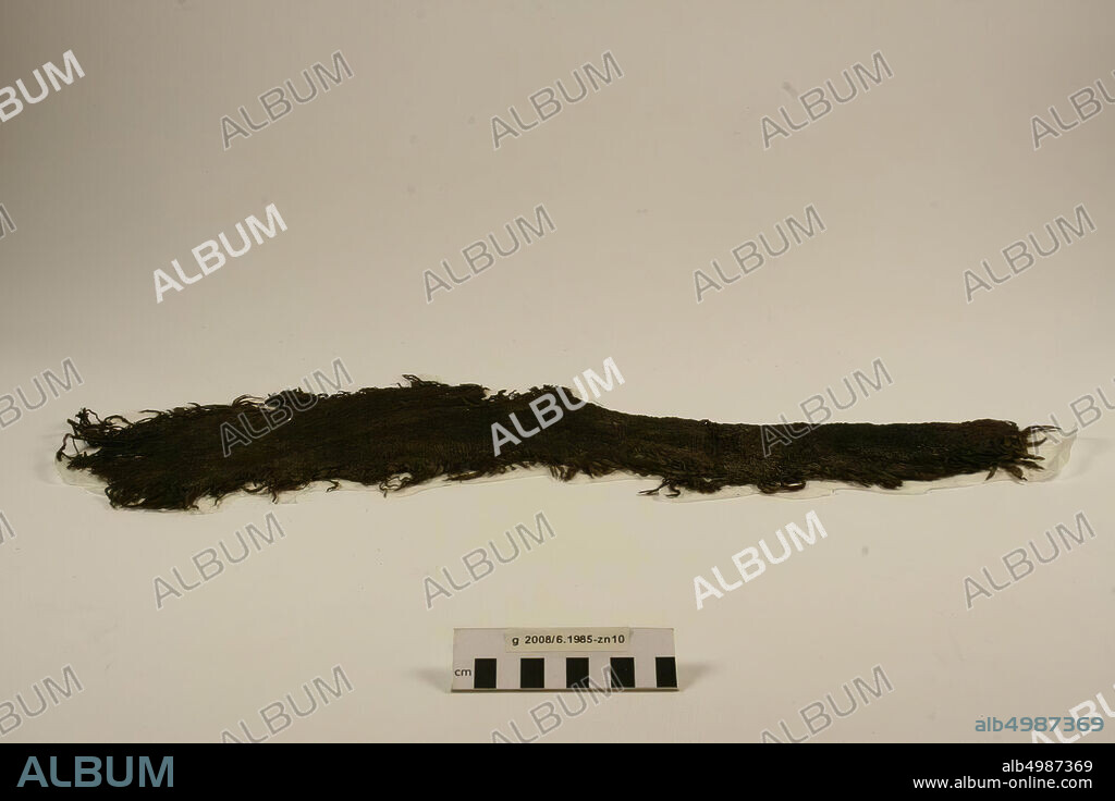 Fragment of a coarse woolen fabric with twill weave, dark brown. A part of the long side is folded (old seam): opening in garment (neck opening or armhole and flaw). Bag with loose threads, textile, fragment, organic, textile, wool, 16 x 56 x 0,7 cm, roman 15-30 AD, Netherlands, North Holland, Velsen, Velsen, Velsen I.